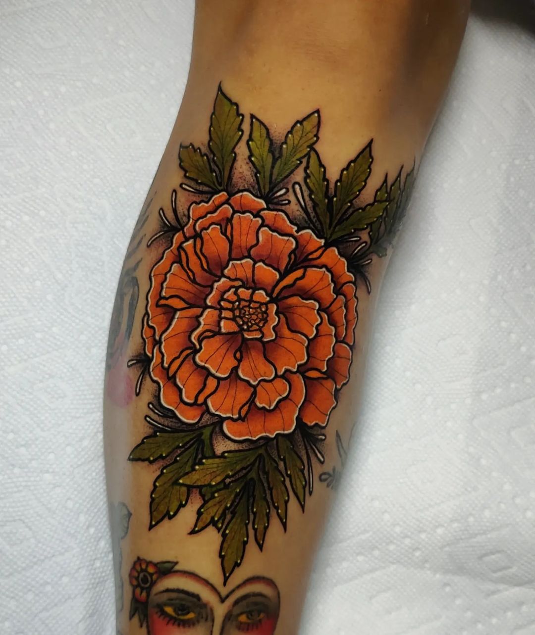 Neo-traditional marigold tattoo on the forearm